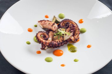 Beyaz bir plaka üzerinde pişirilmiş ahtapot yakın çekim