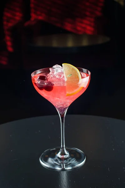 Barman no trabalho, a preparar cocktails. derramando cosmopolita para copo de coquetel . — Fotografia de Stock