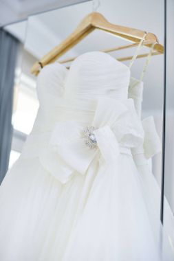 Gelinlik aynada asılı.