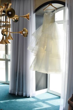 Gelinlik aynada asılı.