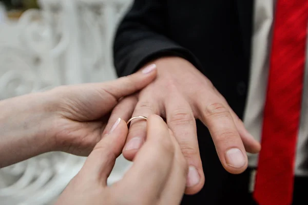 Hochzeitstag. legt der Bräutigam den Ring an die Hand der Braut. Foto Nahaufnahme — Stockfoto