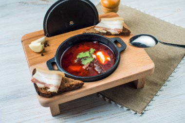 Bir dökme demir kapta, Ukrayna mutfağından geleneksel yemeği pancar çorbası-pancar çorbası. Yatay projeksiyon.