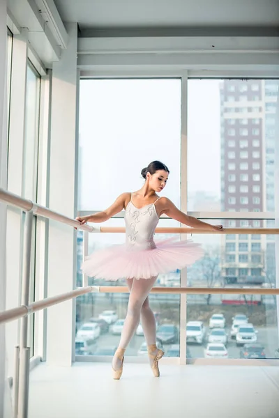 Młoda i niesamowicie piękna balerina pozuje i tańczy w białym studiu pełnym światła. — Zdjęcie stockowe