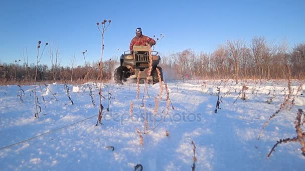 ATV cabalgando en la nieve retroiluminación velocidad tiro lento — Vídeos de Stock