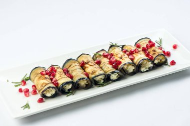 Patlıcan fındık ile. Fındık, otlar ve nar taneleri ile lezzetli kızarmış patlıcan meze. Gürcü mutfağı yemek beyaz arka plan üzerinde beyaz plaka üzerinde