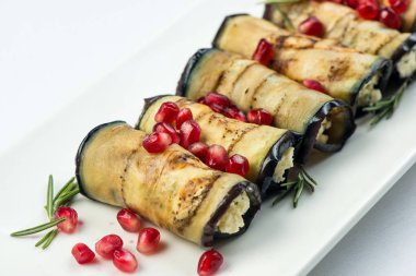 Patlıcan fındık ile. Fındık, otlar ve nar taneleri ile lezzetli kızarmış patlıcan meze. Gürcü mutfağı yemek beyaz arka plan üzerinde beyaz plaka üzerinde