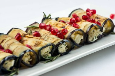 Patlıcan fındık ile. Fındık, otlar ve nar taneleri ile lezzetli kızarmış patlıcan meze. Gürcü mutfağı yemek beyaz arka plan üzerinde beyaz plaka üzerinde