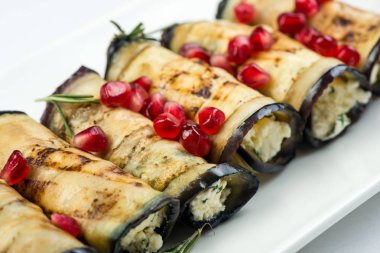 Patlıcan fındık ile. Fındık, otlar ve nar taneleri ile lezzetli kızarmış patlıcan meze. Gürcü mutfağı yemek beyaz arka plan üzerinde beyaz plaka üzerinde