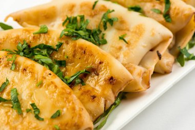 Beyaz arka plan üzerinde beyaz tabakta limonlu kızarmış kalamar gövdesini