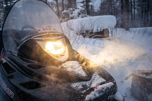 Snowmobile à noite atravessa a floresta de inverno. faróis. estrada noturna através da floresta de inverno. snowmobile à noite — Fotografia de Stock