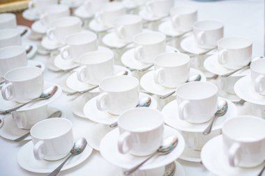 Bir sürü beyaz kahve fincanı. Çay ya da kahve için boş beyaz fincanlar halinde dizilmiş pek çok kişinin üst görüntüsü