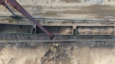 Kariyer kazıcılarının yardımıyla vagonlara kum yüklüyorlar.