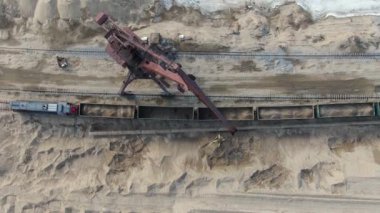 Kariyer kazıcılarının yardımıyla vagonlara kum yüklüyorlar.