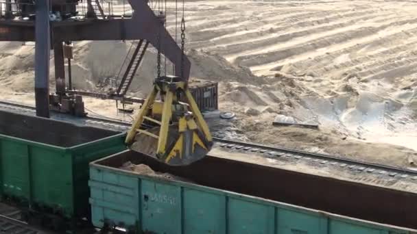 Carregamento de areia em vagões ferroviários com a ajuda de uma escavadora de carreira — Vídeo de Stock