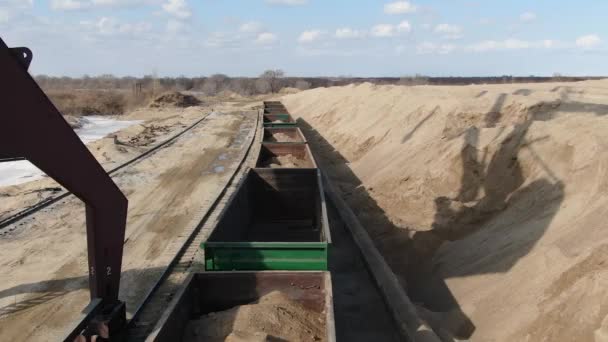 Zandstrooien in spoorwagons met behulp van een loopgraafmachine — Stockvideo