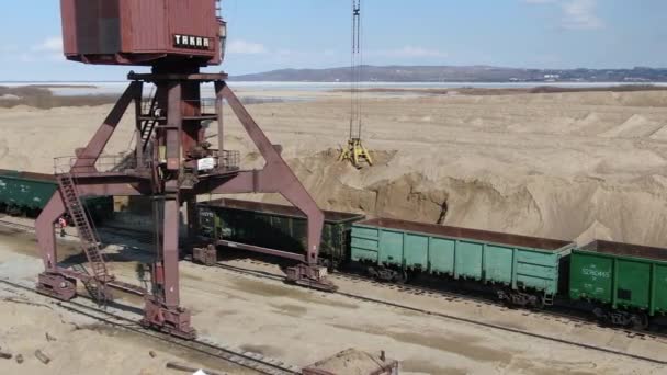 Carregamento de areia em vagões ferroviários com a ajuda de uma escavadora de carreira — Vídeo de Stock