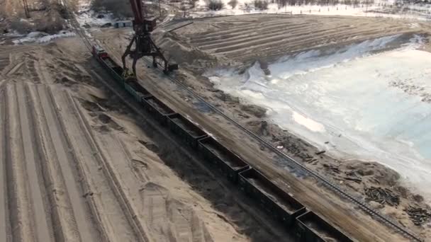 Loading sand into rail cars with the help of a career excavator — Stock Video