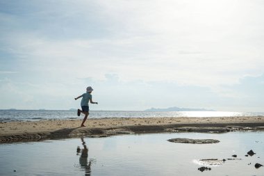 Siluet, suda yansıyan bir çocuk.