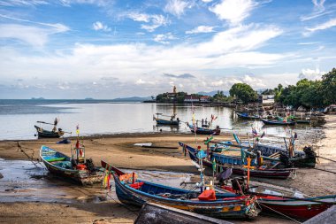 Dalgalar alçaldığında kıyıda balıkçı tekneleri. Tayland