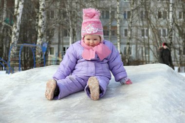 Küçük bir kız buz slayt aşağı yuvarlandı