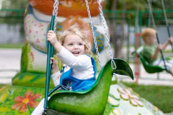 Jolie petite fille chevauchant sur un carrousel — Photo