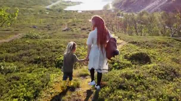 母親と子供が高い山から降りて 振り向いて撮影している人を見る — ストック動画