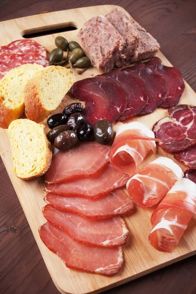 Charcuterie board with cured meat and olives — Stock Photo, Image