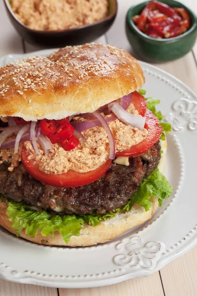 Pljeskavica, serbian burger with urnebes topping — Stock Photo, Image