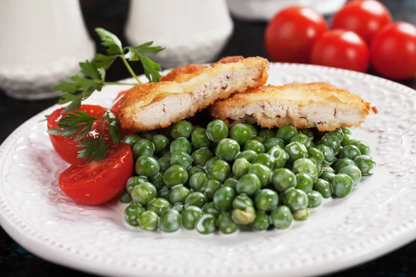Breaded chicken steak with green peas — Stock Photo, Image