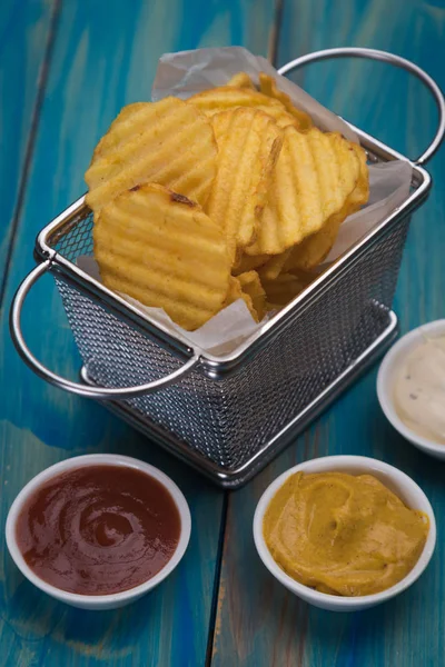 Potato chips in frying basket — Stock Photo, Image