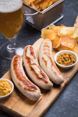 Mostard ve kızarmış patatesli Alman sosisi.