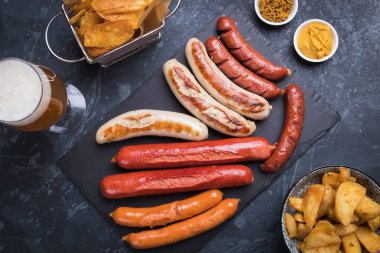 Mostard ve kızarmış patatesli Alman sosisi.