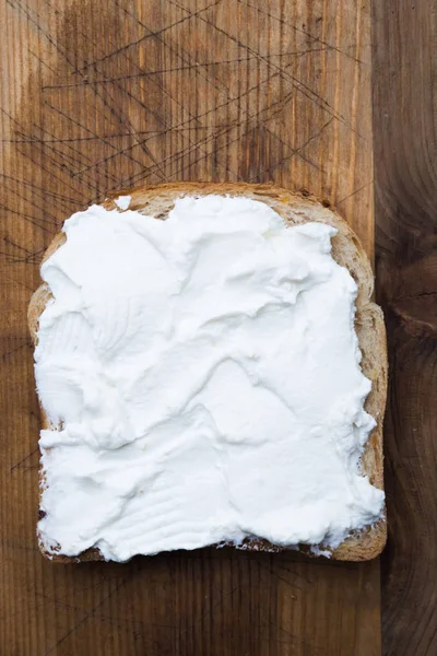 Rebanada de pan tostado con crema agria untada — Foto de Stock