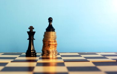 Satranç parçaları üzerinde yığılmış paralar