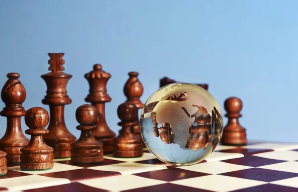 Figuras de xadrez contra o globo terrestre — Fotografia de Stock