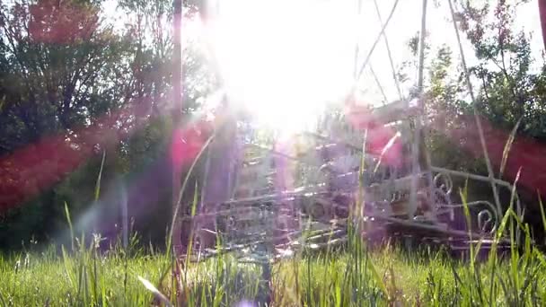 Swingende lege schommels tegen zonlicht — Stockvideo