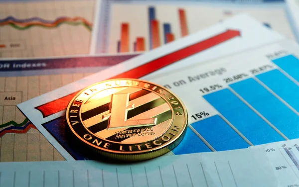 Un litecoin dorado en gráfico y diagramas — Foto de Stock