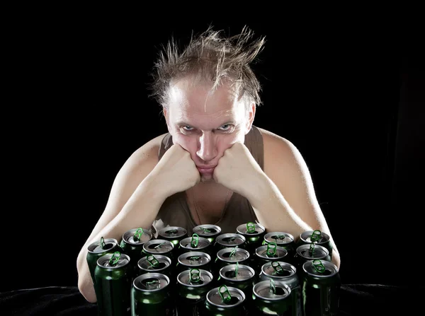 Hangover.The hombre borracho y es un montón de latas de cerveza vacías — Foto de Stock