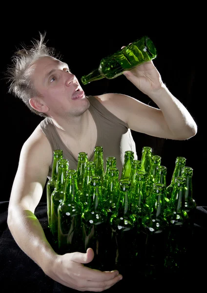 O homem gordo senta-se com um monte de garrafas de cerveja, uma ressaca — Fotografia de Stock