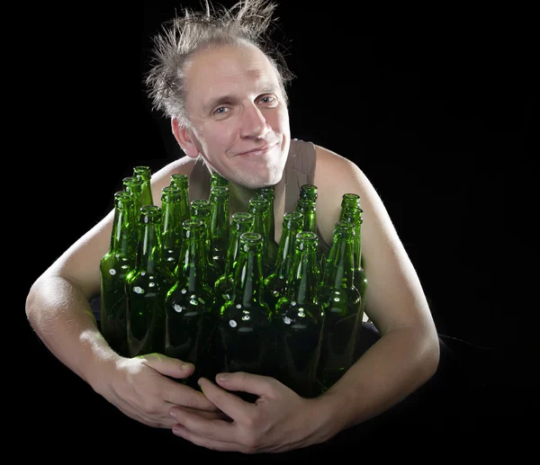 The happy tipsy man near empty beer bottles — Stock Photo, Image