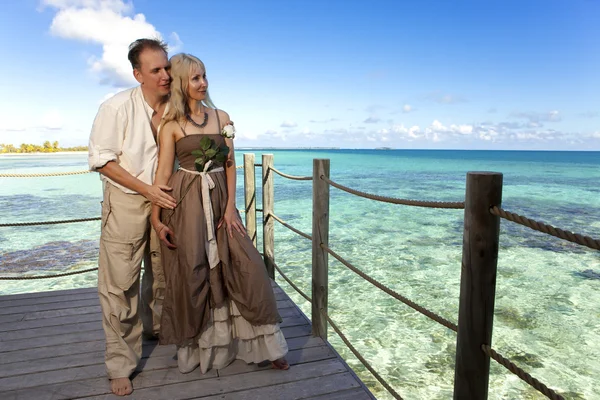 Loving couple on a wooden platform over the sea on the tropical island — Stock Photo, Image