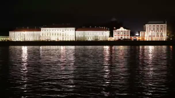 Vista nocturna del terraplén de la Universidad de San Petersburgo a través del río Neva Peter y Paul fortaleza, Palacio puente, isla Vasilievsky . — Vídeos de Stock