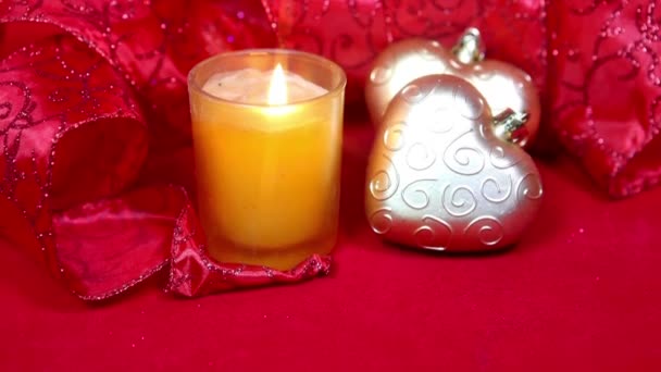Composizione di anno nuovo su uno sfondo rosso - palla e nastro e una candela — Video Stock