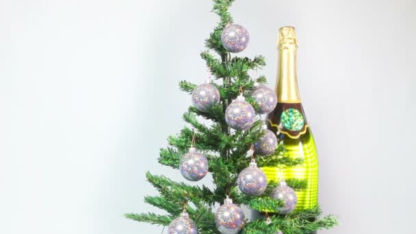 Bolas de Año Nuevo en un árbol de Año Nuevo y una enorme botella de vino espumoso — Vídeo de stock