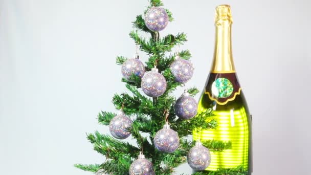 New Year's balls on a New Year tree and a huge bottle of sparkling wine — Stock Video