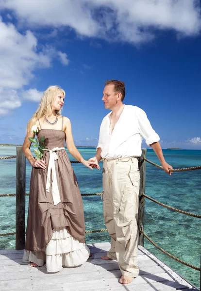 Loving couple on a wooden platform over the sea on the tropical island — Stock Photo, Image