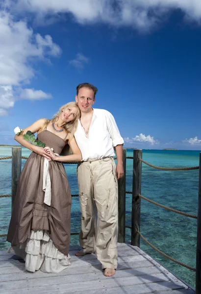 Loving couple on a wooden platform over the sea on the tropical island — Stock Photo, Image