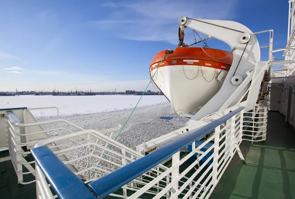 Blick aus dem mit Eis bedeckten Golf von Finnland auf den Hafen von St. Petersburg und ein Rettungsboot von einem Schiff im Vordergrund. Russland — Stockfoto