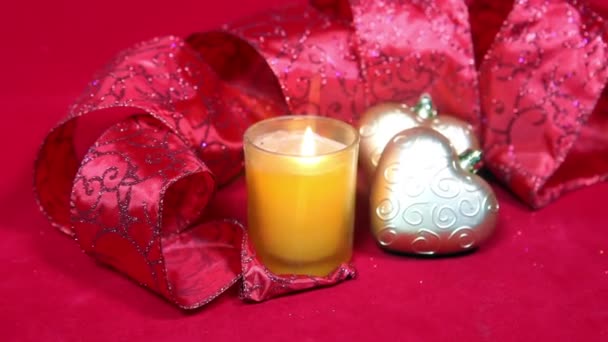 Новогодняя композиция на красном фоне - шар и лента и свеча — стоковое видео