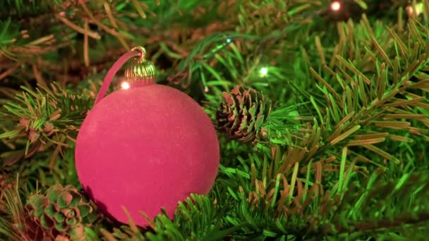 Bola Tahun Baru merah terhadap latar belakang dari hiasan karangan bunga dari pohon Natal — Stok Video